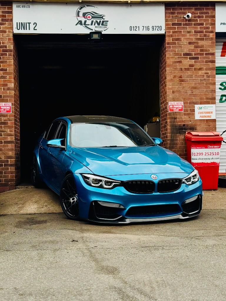 Blue BMW at the Aline Motor Care workshop entrance in Birmingham