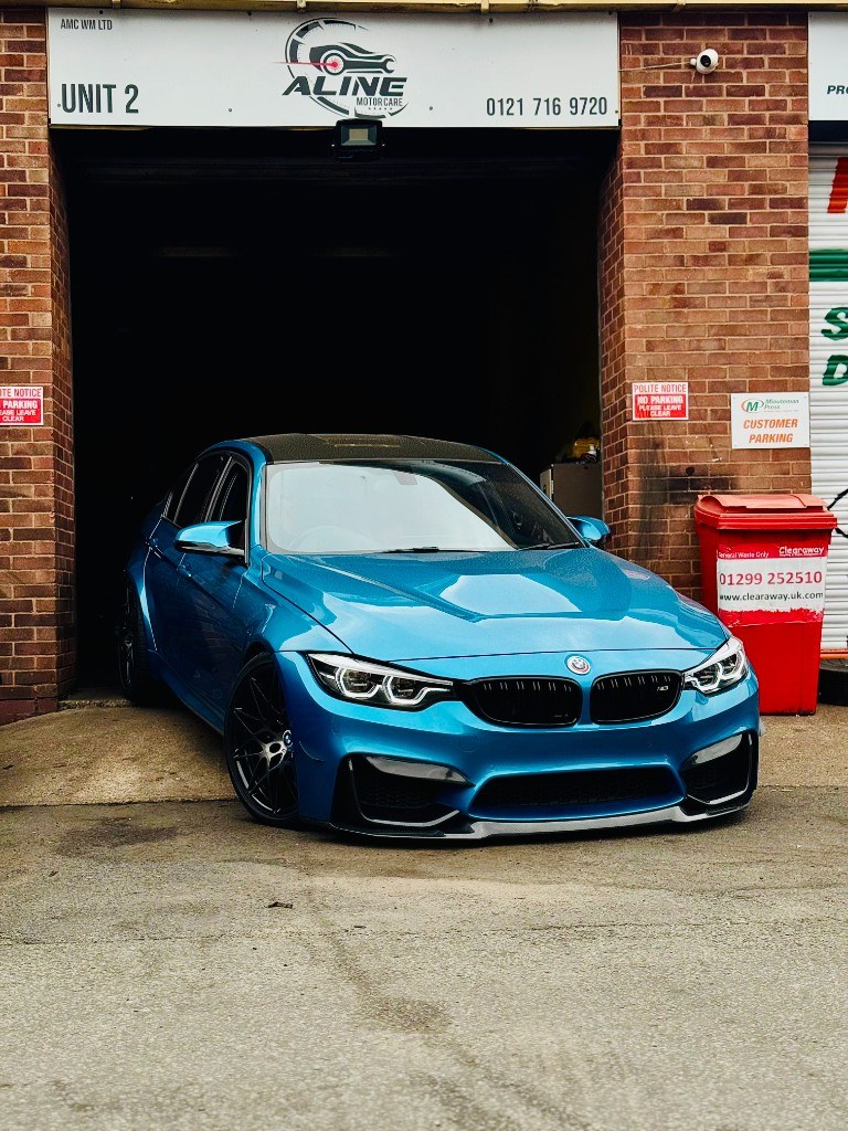 Blue BMW at the Aline Motor Care workshop entrance in Birmingham